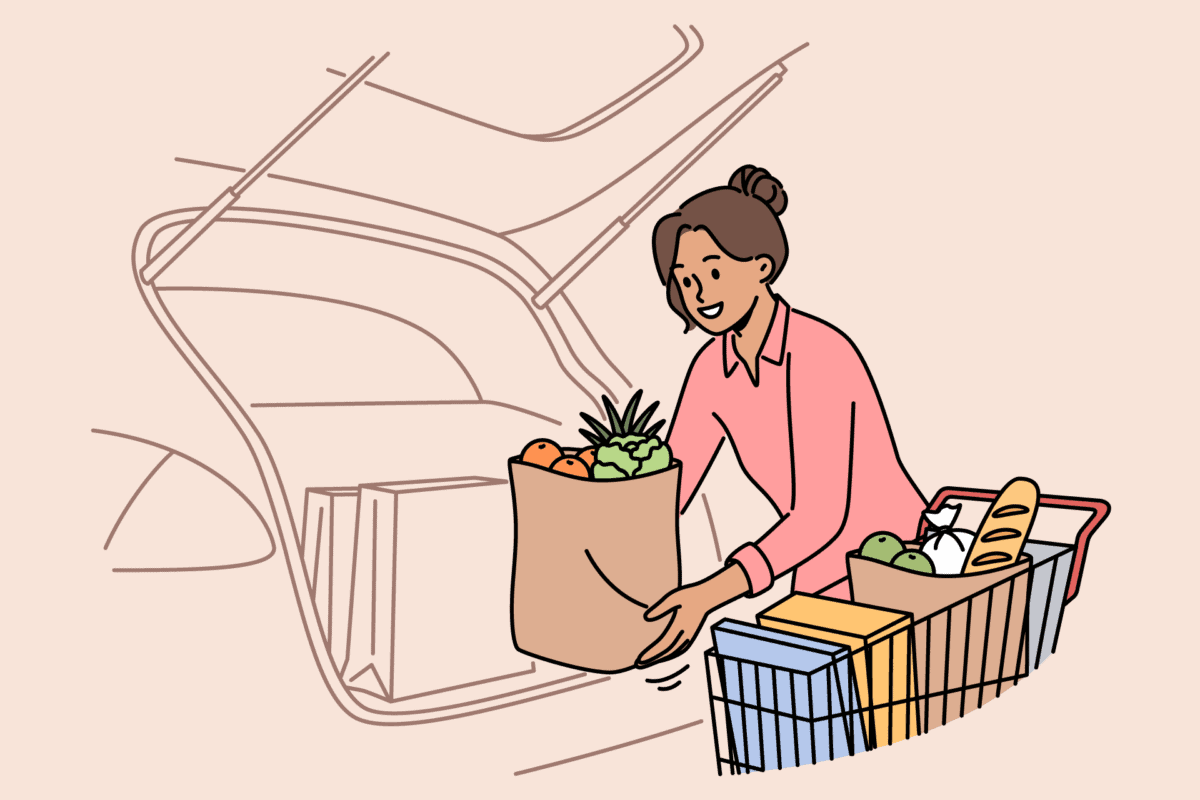 Woman loading groceries into her car trunk